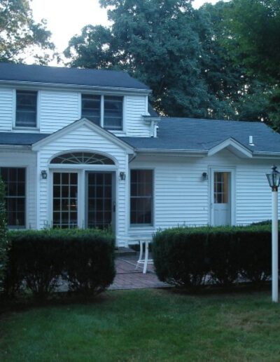 A white house with a fenced in yard.