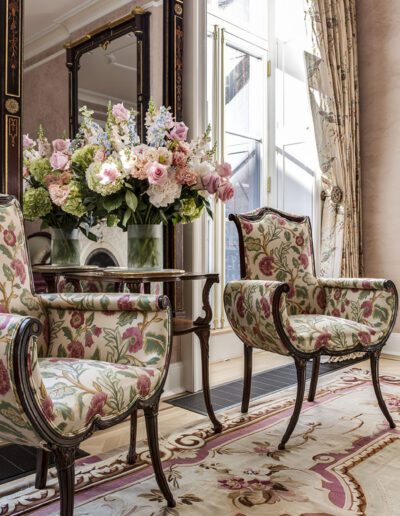 A living room with two chairs and a vase of flowers.