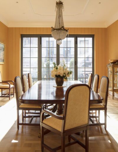 A dining room with yellow walls and a fireplace.