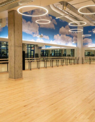 An empty dance studio with a ceiling painted with clouds.