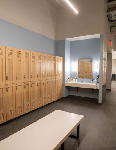 A locker room with wooden lockers and a bench.