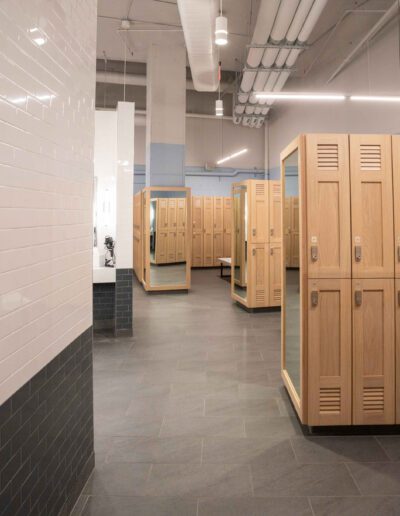 A locker room with wooden lockers and tiled floors.