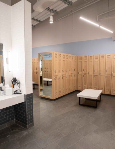 A locker room with wooden lockers and mirrors.