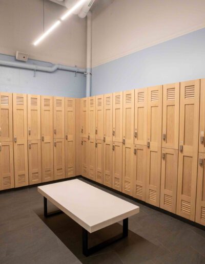 A locker room with wooden lockers and a bench.