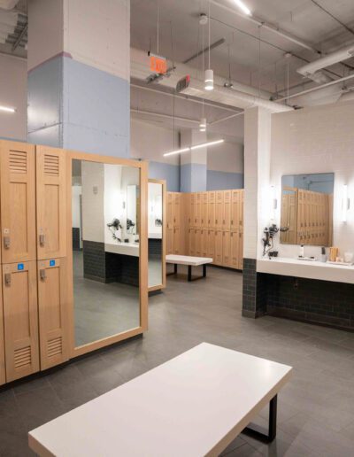 A locker room with wooden lockers and mirrors.