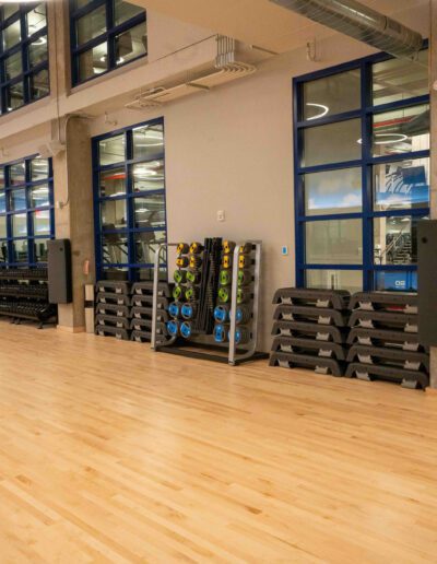 A gym with wooden floors and large windows.