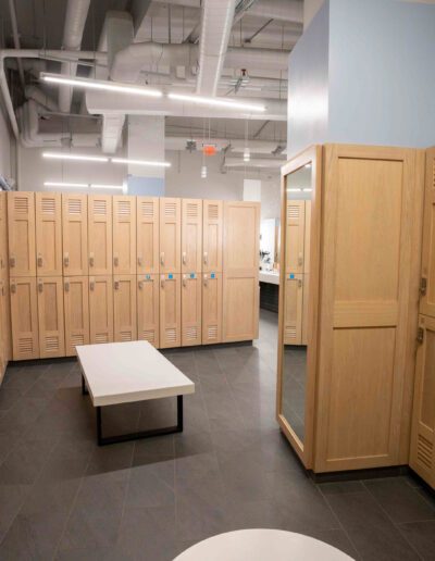 A locker room with wooden lockers and a bench.