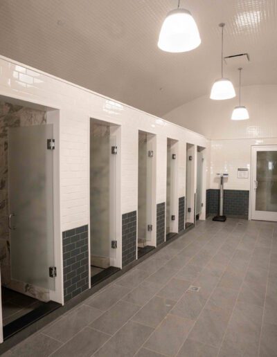 A row of stalls in a bathroom.