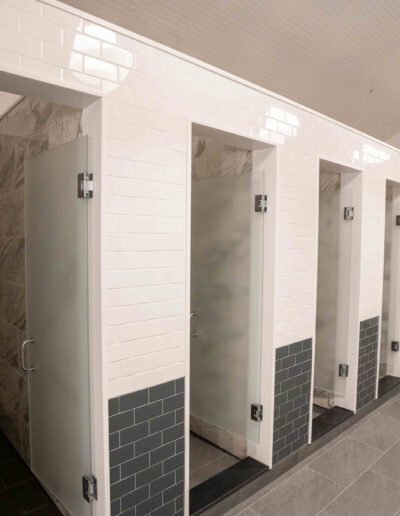 A row of stalls in a bathroom.