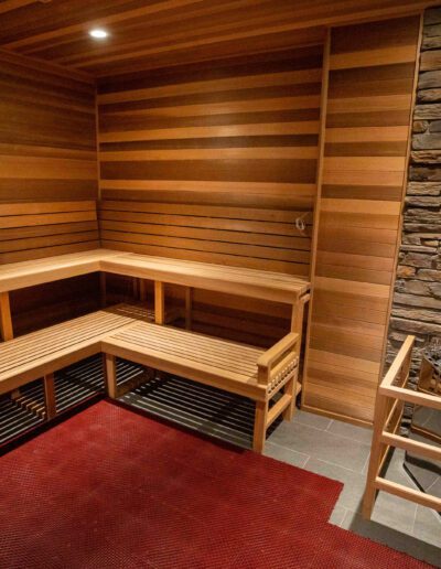 A sauna room with wooden benches and a fireplace.