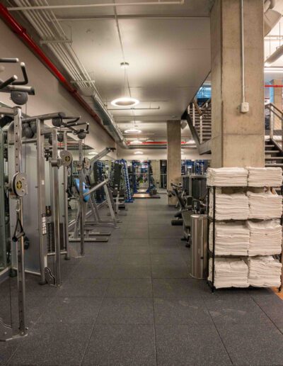 A gym with a lot of equipment and stairs.