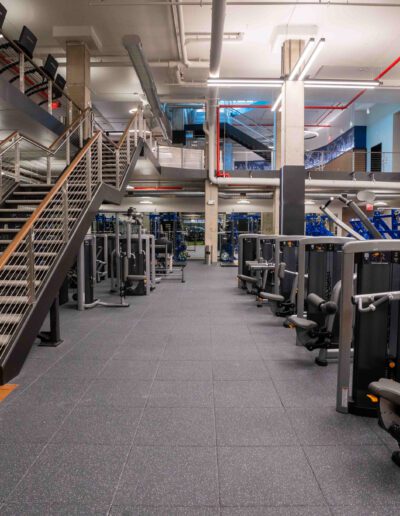 A gym with a lot of equipment and stairs.