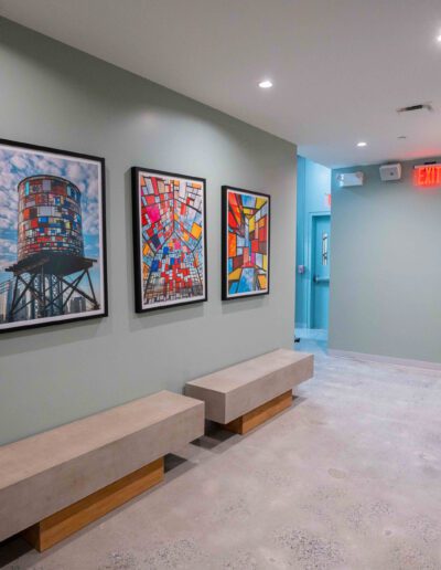 A hallway with a bench and framed pictures.