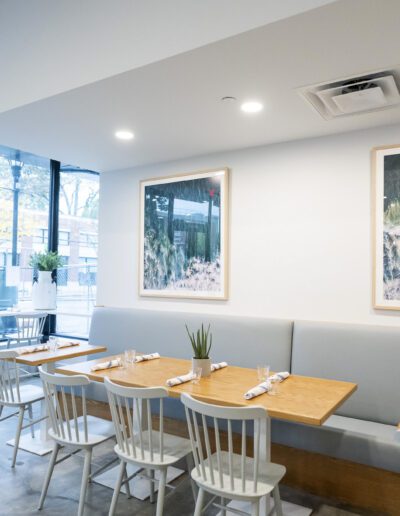 The interior of a restaurant with white tables and chairs.