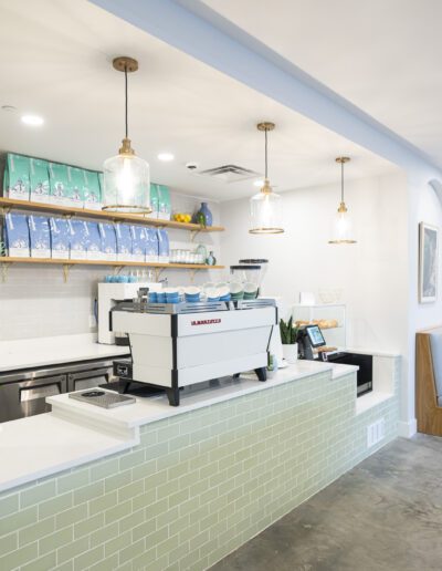 A restaurant with a counter and a green tiled wall.