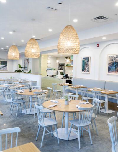 The interior of a restaurant with white tables and chairs.